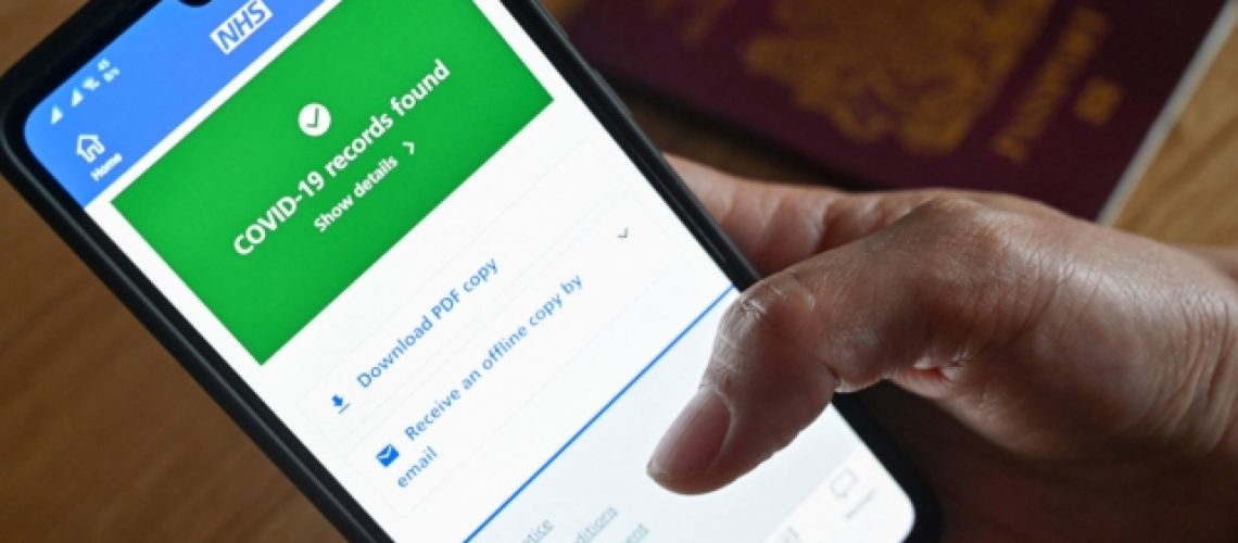An illustration picture shows a smartphone screen displaying a Covid-19 vaccine record on the National Health Service (NHS) app in London on May 18, 2021. (Photo by JUSTIN TALLIS / AFP) (Photo by JUSTIN TALLIS/AFP via Getty Images)